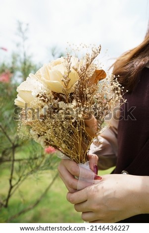 girl holding unreal bouquet of dry flowers,unreal object for taking picture as props