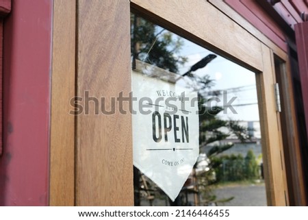 A white sign with the words "open" is affixed to the entrance glass door.