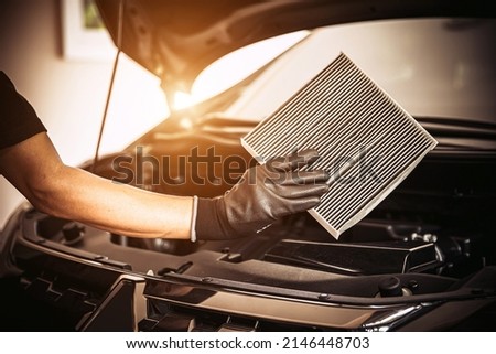 Hand of mechanic holding car air filter old and dirty with dust stains for checking cleaning and replacing new filter. Concept of car care service maintenance. Royalty-Free Stock Photo #2146448703