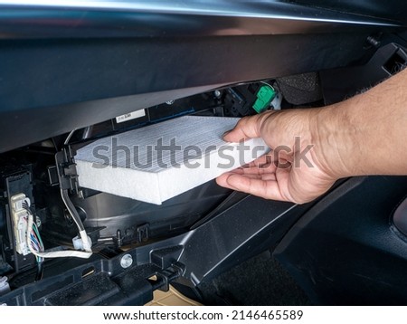 Replacement air filter for car. Hand of the car user for maintenance airconditioner filter by replacement concept DIY inside his car Royalty-Free Stock Photo #2146465589