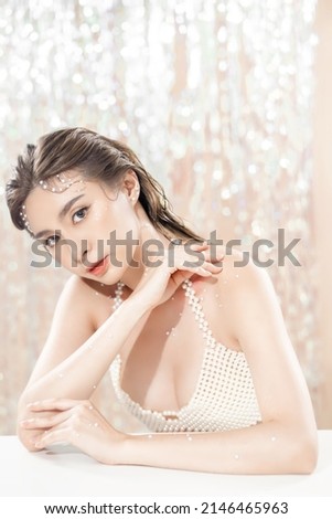 Beautiful young asian woman with clean fresh skin with pearls on glitter background. Face care, Facial treatment, beauty and spa, Cute Asian women portrait.
