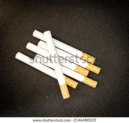 some white and brown cigarettes, cigarettes are only allowed for 18+ and above, black background