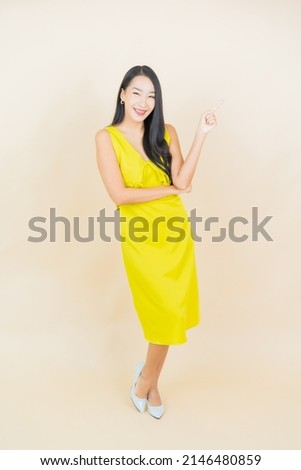 Portrait beautiful young asian woman smile with action on cream background
