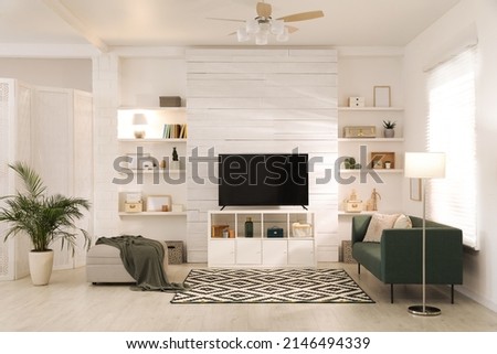 Cozy room interior with stylish furniture, decor and modern TV set Royalty-Free Stock Photo #2146494339