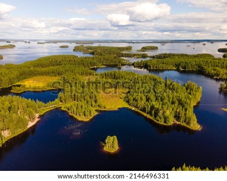 Beautiful sunny day over a calm lake with many islands. Aerial view of a Finnish lake