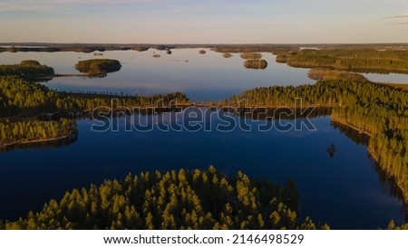 Amazing sunset evening over a Finnish calm lake. Tranquil summer night in the Nordics. Aerial view