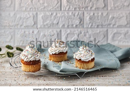 Homemade cupcakes with whipped cream and pralines, still warm for breakfast or an afternoon snack. Present yourself on the dessert cooling rack