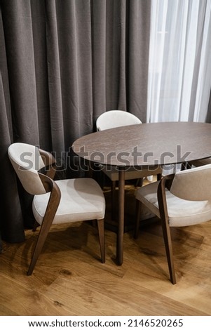 light chairs with dark wood and a dark table made of natural wood in the interior of the house