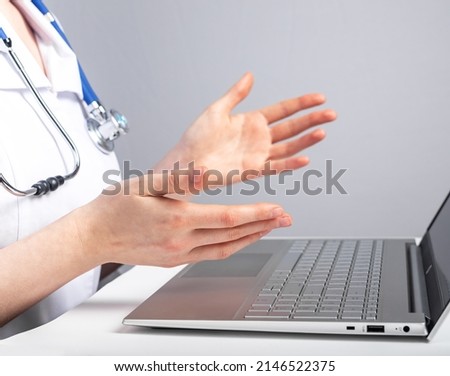 Doctor with stethoscope giving online consultation to patient. Healthcare and telemedicine concept. Woman in lab coat sitting at desk with laptop and advising people with illness remotely. photo