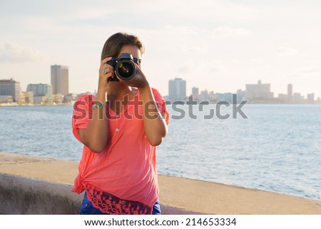 Portrait of young girl in la habana, cuba, taking pictures and photo looking at camera through viewfinder