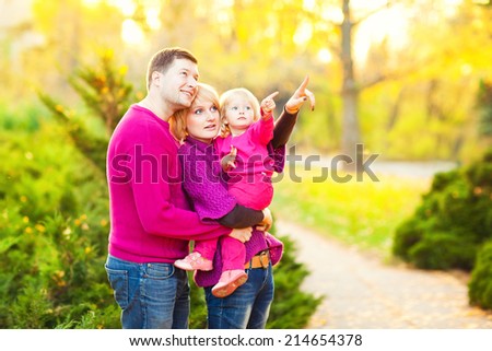 Picture of lovely family in autumn park, young parents with nice adorable kid playing outdoors. Picnic in the autumn park.