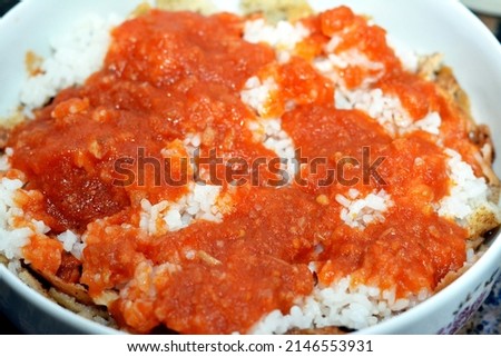 Selective focus of Arabic Egyptian cuisine, Egyptian oriental Fattah with white rice and crispy bread topped with seasoned garlic red tomato sauce made by cow trotters soup