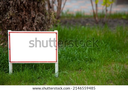 Pointer sign on the lawn with green grass. Banner layout with place for the text dog walking is prohibited , do not walk on the lawn, it is dangerous. Information board layout. Mockup.