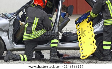 firefighters in action during the rescue of the injured after the car accident with the stretcher to transport the injured Royalty-Free Stock Photo #2146566917