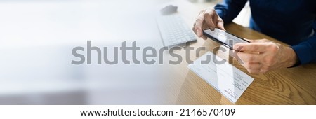 Remote Check Deposit Taking Photo With Mobile Phone Royalty-Free Stock Photo #2146570409