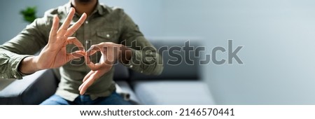 Man Using Sign Language To Communicate At Home Royalty-Free Stock Photo #2146570441