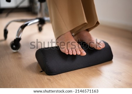 Worker Using Footrest To Reduce Back Strain And Feet Fatigue Royalty-Free Stock Photo #2146571163