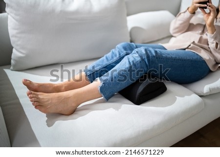 Woman Using Footrest To Reduce Back Strain And Feet Fatigue Royalty-Free Stock Photo #2146571229