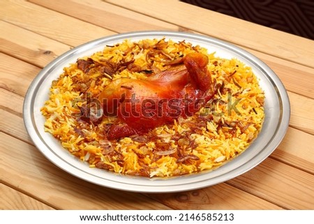 Chicken  known as Biryani or at  wooden background. is Saudi Arabian cuisine dish It cooks with basmati rice chicken spices tomatoes nuts raisins