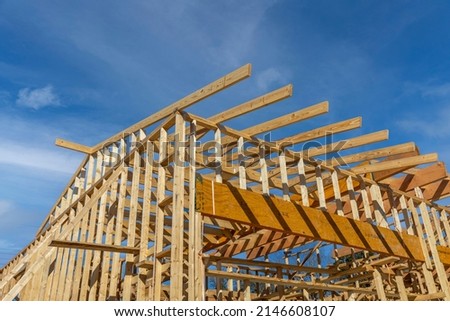 Roof with wooden truss, post and beam framework and blue sky. Royalty-Free Stock Photo #2146608107