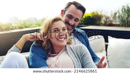This is what you call a perfect holiday. Shot of an affectionate mature couple relaxing on couch outdoors while on holiday. Royalty-Free Stock Photo #2146625861