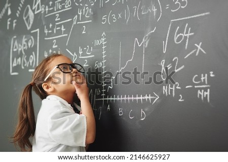 Shes way to clever for her age. Shot of an academically gifted young girl solving a math equation. Royalty-Free Stock Photo #2146625927