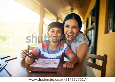 I adore spending any type of time with my son. Cropped shot of a young beautiful mother colouring in pictures with her adorable son at home.