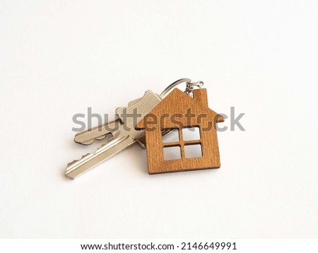 The concept of mortgage lending for the purchase of new housing. Keys with a wooden keychain small house on a white background. Place for text.