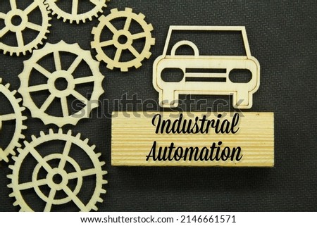cars and wooden gear wheels are arranged with the words industrial automation