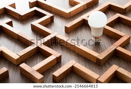 Light bulb in the maze game built by wood blocks, finding the right way to the success, searching creative idea concept Royalty-Free Stock Photo #2146664813