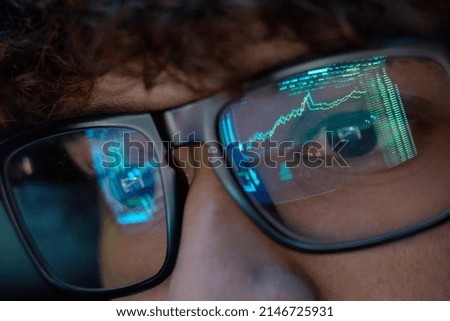 Young indian business man trader wearing glasses looking at computer screen with trading charts reflecting in eyeglasses watching stock trading market financial data growth concept, close up. Royalty-Free Stock Photo #2146725931