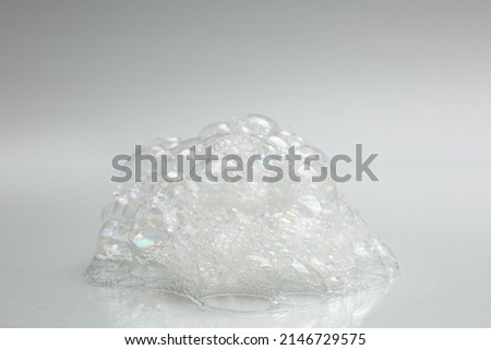 Drop of fluffy bath foam on light background