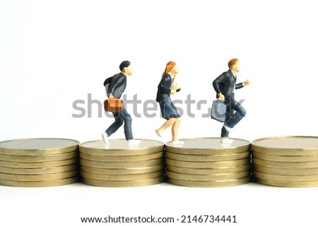 Miniature people toy figure photography. School admission budget concept. Pupils running above golden coin stack cent money, isolated on white background. Image photo