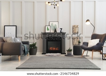 Stylish living room interior with electric fireplace and comfortable furniture Royalty-Free Stock Photo #2146734829