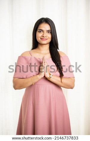 Pretty Indian young woman greeting on white.