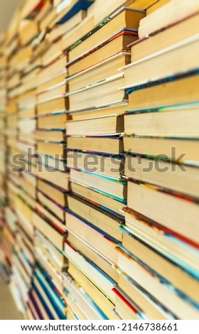 Endless wall of old books stack background. Colorful educational used books folded in many pile columns. Collecting in the library and how to choose only one book vertical photo