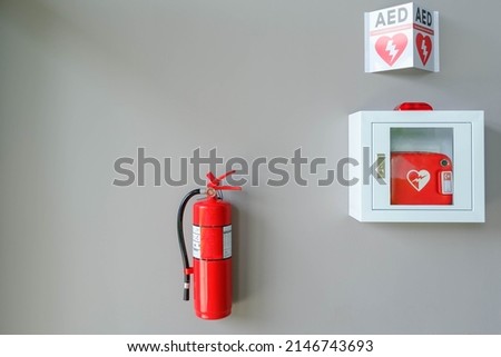 Fire alarm system on a brick an emergency during fire.Automated External Defibrillator AED emergency life saving equipment mounted on wall of rowing club.