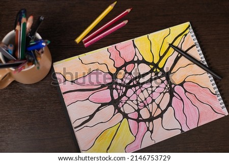 Neurographic drawing, relaxation for body and brain. Mental health of soul and body, neurolines, neural connections. psychological technique, psychology. Black marker pen on a multicolored drawing.