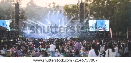 Blurred people watching concert in the park at open air,Summer festival concert.Light from the stage. Royalty-Free Stock Photo #2146759807