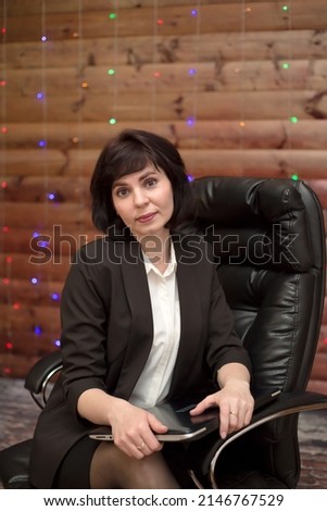 Beautiful young woman director of a large company in a chair.