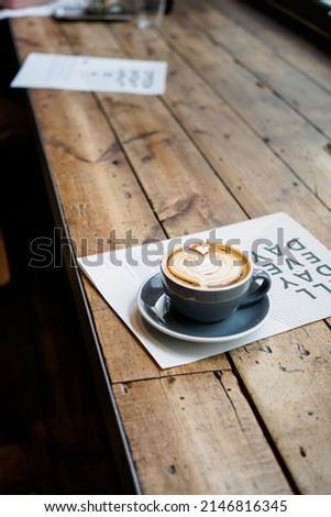 Beautiful cappuccino on wooden table in a coffeeshop