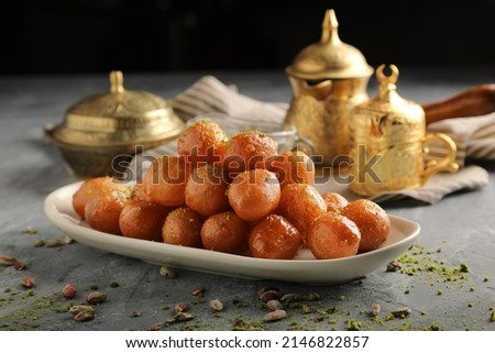 luqaimat or lokma. Freshly fried Lokma (luqma - arabic) piled high a popular middle eastern dessert of small dough balls deep fried then coated in sugar or honey syrup Royalty-Free Stock Photo #2146822857