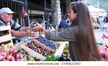 Girl buying fresh figs in local shop