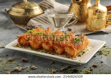 Homemade arabian traditional sweets Kunafa or konafa roll with cheese or cream and sugar syrup pistachio on top Royalty-Free Stock Photo #2146826509