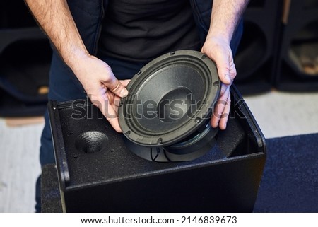 Worker is production speakers and loudspeakers at the factory. Handmade creation of acoustic music systems Royalty-Free Stock Photo #2146839673