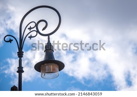 Beautiful forged lantern in the old city against the blue sky