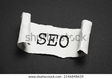 SEO Solutions the inscription appearing behind the torn cardboard paper. High quality photo