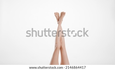 Crossed smooth female legs on light grey background | Leg care concept Royalty-Free Stock Photo #2146864417