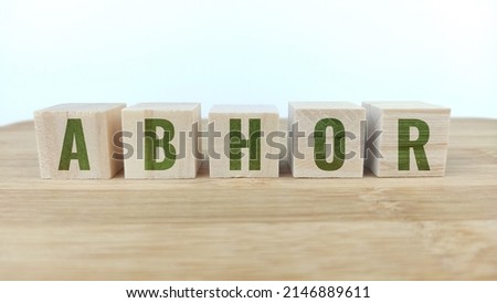 Word abhor written with wood cubes on table