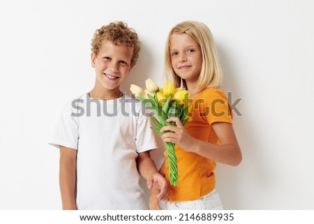 Boy and girl with a bouquet of flowers gift birthday holiday childhood light background
